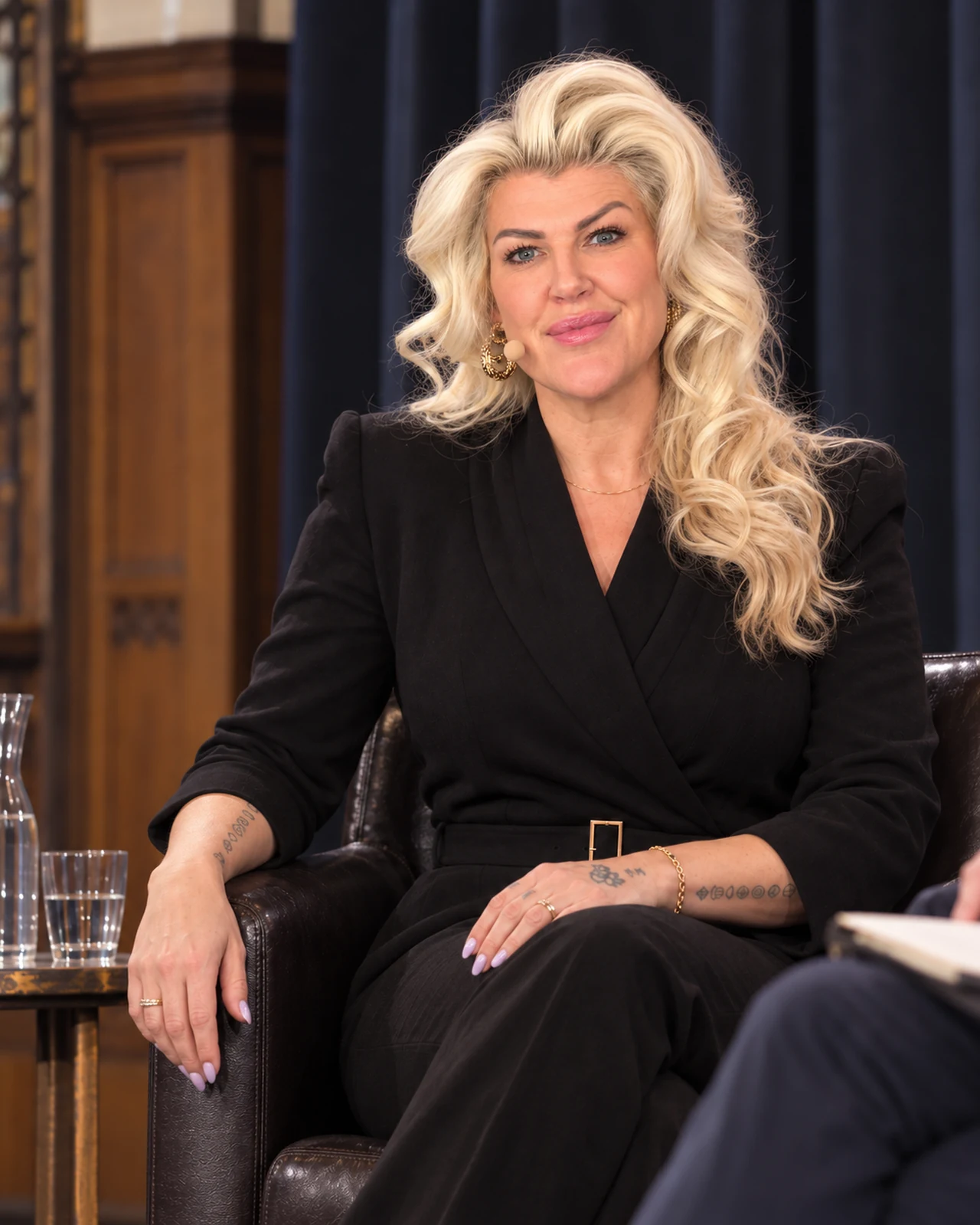 Penny Dee seated on a panel, looking towards the camera